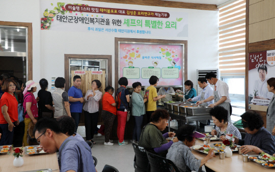 지난 3일 태안군장애인복지관에서 김성운 셰프가 만든 음식을 고객과 직원들에게 배식하고 있는 모습.사진=태안군 제공
