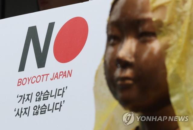 26일 서울 종로구 옛 일본대사관 앞 소녀상 뒤로 일본 제품 불매 운동 포스터가 보이고 있다.  [연합뉴스]
