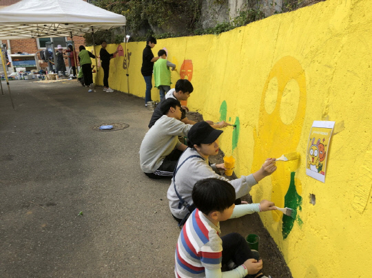 홍성지역 내 초등학생과 학부모들이 `안전한 길 조성`을 위해 서해삼육초등학교 주변 담장에 벽화그리기 작업을 하고 있다. 사진=홍성군 제공
