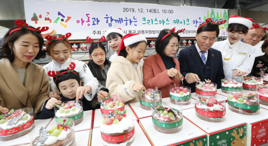 황인호 대전 동구청장과 이나영 동구의회 의장이 행사 참석자들과 함께 크리스마스 케이크를 만들고 있는 모습. 사진=대전 동구청 제공 
