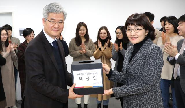 30일 대전문화재단 박만우(왼쪽) 대표이사가 직원들과 함께 모은 외국동전을 남상현 대전일보 부회장에게 전달하고 있다. 사진=빈운용 기자
