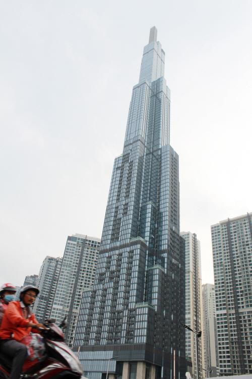 베트남의 경제성장을 상징하는 `랜드마크 81` 빌딩 앞으로 오토바이를 탄 사람들이 지나고 있다. 높이 461.2m, 지하 3층, 지상 81층인 랜드마크 81은 호치민에서 가장 높은 것은 물론 인도차이나반도에서 최고층 건물이기도 하다.사진=문승현 기자