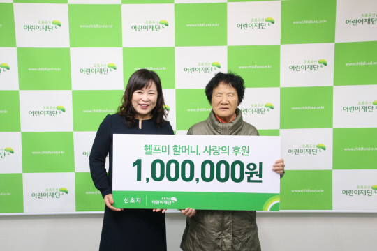`헬프미 할머니` 신초지 여사(우측)가 박미애 초록우산어린이재단 대전지역본부장(좌측)에게 후원금 100만원을 전달하고 있다. 사진=초록우산어린이재단 제공

