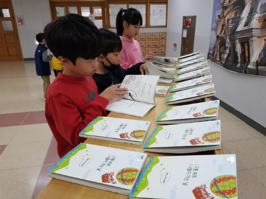 출판기념회에 초대받은 학생들이 출판물을 보고 있다. 사진=두루초등학교 제공
