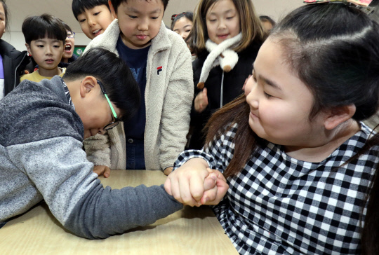 겨울방학을 마치고 개학을 한 15일 대전대동초등학교 3학 1반 학생들이 오랜만에 만난 친구와 팔씨름을 하고 있다. 빈운용 기자
