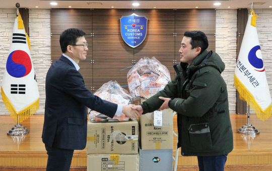 양을수 인천세관 통관지원과장(사진 왼쪽)이 18일 한국사회복지협의회 산하 인천 푸드마켓 유현우 사회복지사에게 마스크를 전달하고 있다. 사진=관세청 제공 

