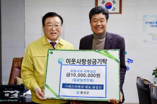 최정곤(오른쪽) (주)에스이엔지 대표가 13일 김석환 홍성군수에게 코로나19 극복 성금 1000만원을 기탁하고 있다. 사진=홍성군 제공
