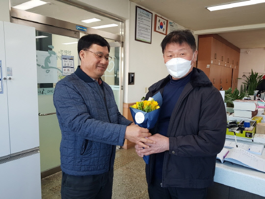 김종희 홍동면장이  코로나19 방역에 힘쓴 마을 이장에게 꽃을 전달하고 있다. 사진=홍성군 제공
