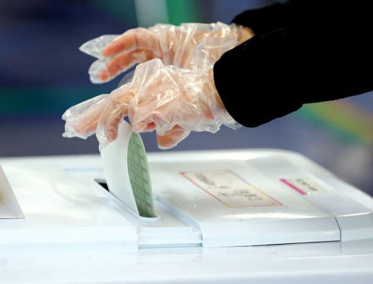 11일 대전시 동구 가오중학교 투표소에서 1회용 장갑을 낀 시민이 투표용지를 투표함에 넣고 있다. [사진=빈운용 기자]