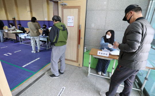 제21대 국회의원 선거일인 15일 대전월평초등학교에 마련된 월평1동 투표소에서 유권자들이 1m 간격을 유지한채 투표순서를 기다리고 있다. 빈운용 기자
