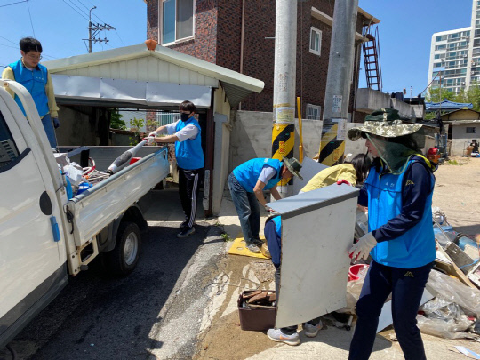 옥천읍 지역사회보장협의체 회원들이 장애인부부가구 각종쓰레기를 청소하고 있다. 사진=옥천군 제공

