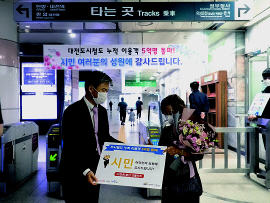 김경철(왼쪽) 대전도시철도공사 사장이 5억번째 승객에게 기념품을 전달하고 있다. 사진=대전도시철도공사 제공
