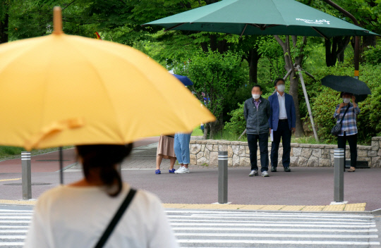 2일 오후 대전지역이 대체로 흐리고 한때 비가 내리면서 대전시 서구 둔산동의 한 네거리에 시민들이 우산을 쓰고 횡단보도를 건너고 있다. 윤종운 기자
