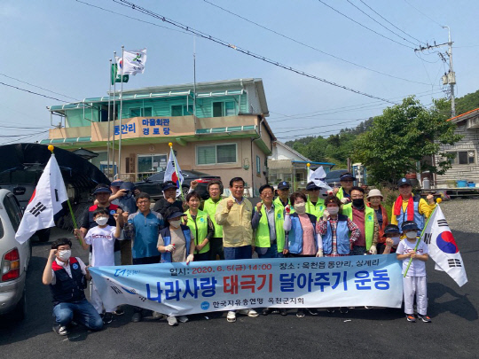 한국자유총연맹 옥천지부회원들은 나라사랑 태극기 달아주기 운동행사를 전개하고 기념촐영하고 있다. 사진=옥천군 제공

