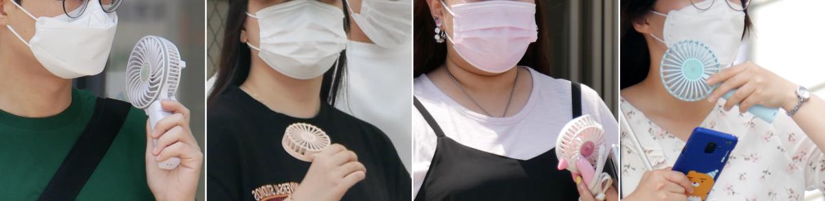 대전 낮 최고기온이 33도까지 올라 폭염주의보가 발효된 8일 오후 대전시 서구 둔산로를 찾은 시민들이 마스크를 쓴 채 휴대용 선풍기로 더위를 식히고 있다. 윤종운 기자
