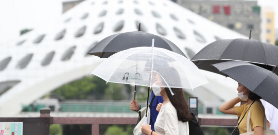 휴일인 12일 오후 장맛비가 내리자 대전 중구 은행동 목척교 인근 시민들이 우산을 쓰고 서둘러 귀가하고 있다. 신호철 기자
