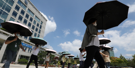 대전 서구청 직원들이 16일 오후 구청 광장에서 여름철 폭염으로 인한 온열질환 및 안전사고를 예방하기 위한 `양산 쓰기 캠페인`을 벌이고 있다. 신호철 기자

