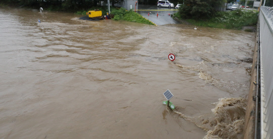 충청지역에 시간당 100mm 이상의 폭우가 쏟아진 30일 대전 갑천 원촌교 지점에 홍수경보가 발령되어 언더패스 도로가 통제되고 있다. 신호철 기자
