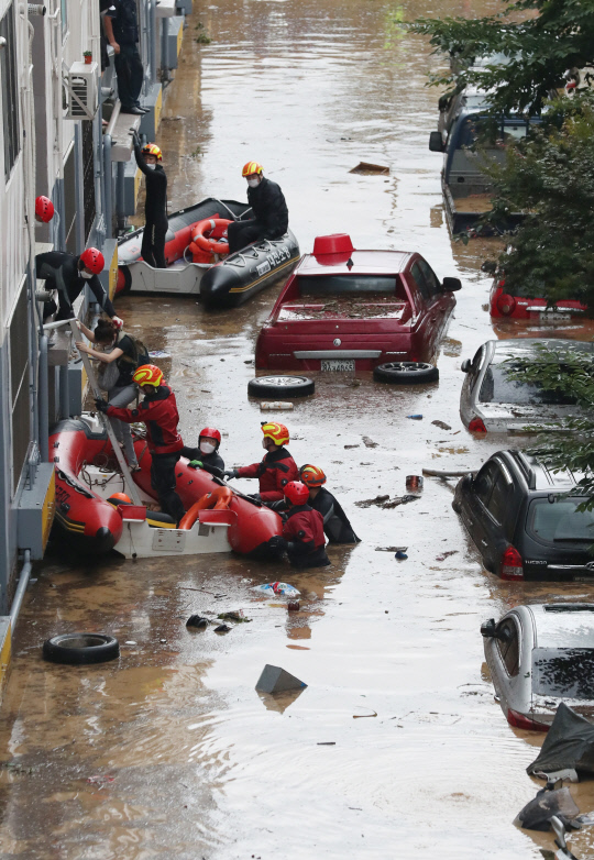 대전 지역에 시간당 100mm 이상의 폭우가 쏟아진 30일 오전 서구 정림동 한 아파트에서 119구조대원들이 보트를 이용해 주민을 구조하고 있다. 신호철 기자
