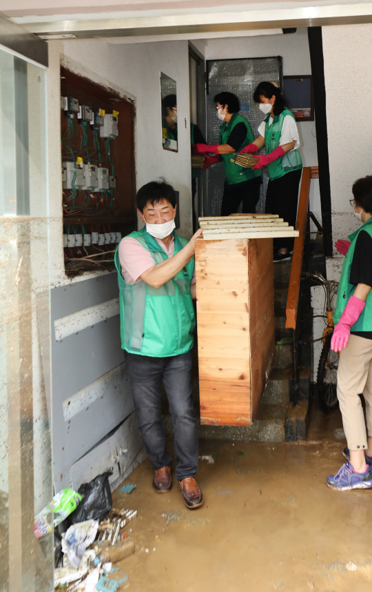 31일 대전 서구 정림동 코스모스아파트에서 자원봉사자들이 전날 내린 폭우로 피해를 입은 현장을  복구하고 있다. 신호철 기
