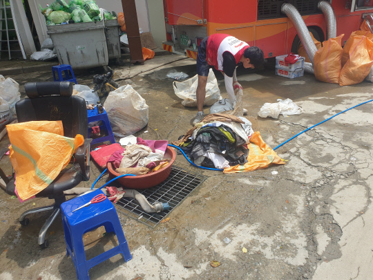 전국재해구호협회 희망브릿지에서 2일 진흙을 가득 머금은 이재민들의 옷가지를 세탁하고 있다. 사진=임용우 기자
