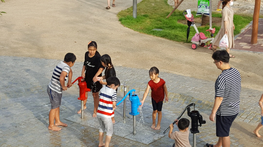 충청권을 강타하던 집중호우가 잠시 그친 5일 오후 5시 30분, 세종시 보람동 `땀범벅 놀이터`에서 어린이들이 수동식 펌프 놀이시설을 사용해 물놀이를 즐기고 있다. 사진=천재상 기자 
