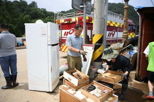 수해현장에서 피해주민의 입장으로 물에 젖은 가구를 옮기고 있는 김봉현의원.사진=박대항 기자
