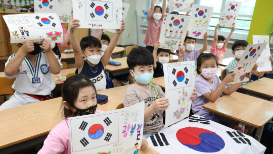 광복절을 이틀 앞둔 13일 오전 대전 둔산초등학교 2학년 학생들이 수업시간에 직접 그린 태극기를 들어 보이고 있다. 신호철 기자
