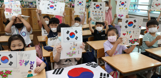 광복절을 이틀 앞둔 13일 오전 대전 둔산초등학교 2학년 학생들이 수업시간에 직접 그린 태극기를 들어 보이고 있다. 신호철 기자
