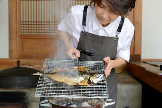 박정남 예미정 안동종가음식교육원장이 숯불에서 안동간고등어를 굽고 있다. 박 원장은 안동간고등어는 물에 불려 소금기를 뺄 필요없이 바로 구워먹을 수 있다고 했다.
