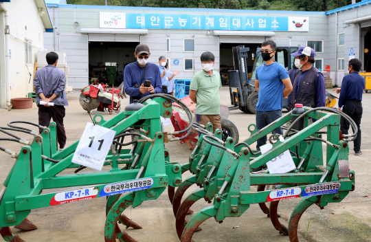 태안군 농기계임대사업소 본소에 매각 대상 불용농기계를 둘러보고 있는 농업인 모습. 사진=태안군 제공
