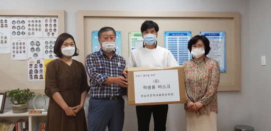 원남초등학교 총동문회 고제욱(왼쪽 2번째) 사무국장이 코로나19로 어려움을 겪고 있는 모교 후배들을 위해 마스크를 기증하고 있다.      사진=원남초 제공
