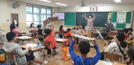 대전 문성초등학교 5학년 교실에서 금연 퀴즈대회가 진행된 가운데 학생들이 퀴즈를 맞추기 위해 손을 높이 들고 있다.  사진=대전시교육청 제공
