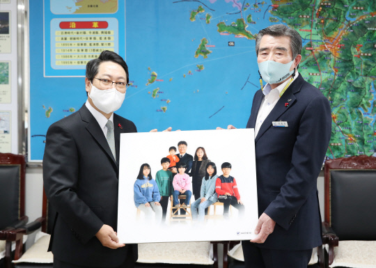 한국프로사진협회 육재원(사진 왼쪽) 회장이 지난 24일 보령시를 찾아 어려운 이웃들의 가족사진을 김동일 시장에게 전달하며 전해줄 것을 요청했다. 사진=보령시 제공
