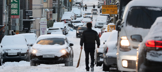 강력한 북극 한파와 함께 눈이 내린 7일 대전 서구 한 주택가 이면도로에 눈이 쌓여 차량들이 뒤엉켜 거북이 운행을 하고 있다. 신호철 기자
