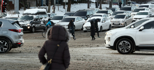 강력한 북극 한파와 함께 눈이 내린 7일 대전 서구 갈마동 큰마을네거리에서 시민들이 몸을 움츠리고 횡단보도를 건너고 있다. 신호철 기자
