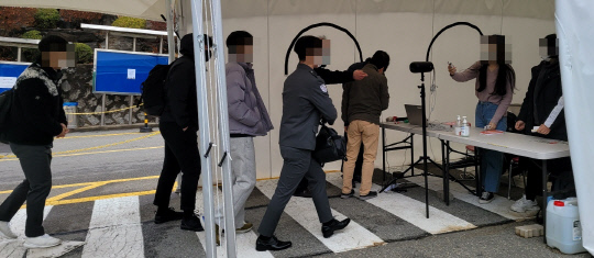 2일 오전 8시쯤 대전보건대에서 학생들이 체온 측정과 방명록을 작성하고 있다. 사진=강정의 기자
