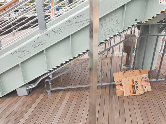 지난 7일 오후 대전 중구 커플브리지 계단 뒤편에 쓰레기가 방치된 가운데 무분별한 낙서가 그려져 있다. 사진=이태민 수습기자
