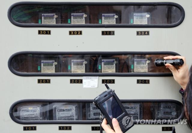 전기검침원이 서울 주택가에서 전기계량기를 확인하는 모습.  [사진=연합뉴스]