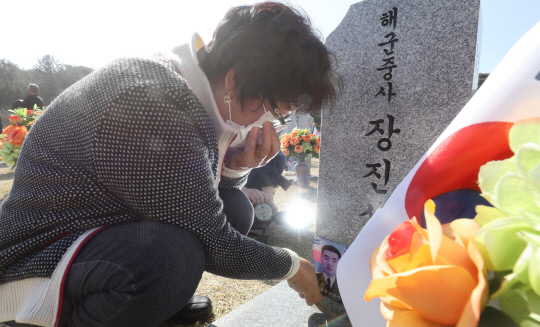 서해수호의 날을 하루 앞둔 25일 대전 유성구 국립대전현충원 천안함46용사 묘역에서 유가족이 아들의 묘비를 만지며 눈물을 흘리고 있다. 신호철 기자
