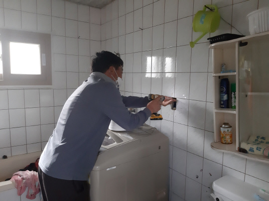 서천군 장항읍 ㈜스마트전력 싱동국 대표가 세탁기를 수리하는 재능기부로 이웃사랑 실천하고 있다. 사진=서천군 제공
