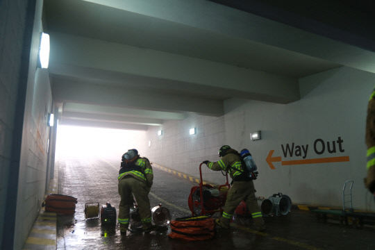 화재가 발생한 지하주차장 내부에서 송풍기를 활용해 배연작업을 하는 소방대원. 사진=서산소반서 제공

