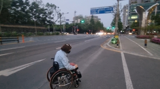 지난 28일 저녁 대전 서구 월평동에서 휠체어를 이용하는 유선경 씨가 도로로 주행하고 있다. 사진=이태민 수습기자
