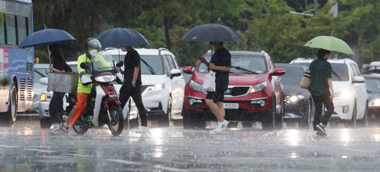 무더위를 식혀주는 비가 내린 2일 대전 유성구 충남대학교 앞 횡단보도에서 시민들이 우산을 쓰고 지나가고 있다. 신호철 기자

