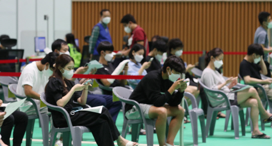 코로나19 백신1차 접종율이 56.5%를 넘어선 가운데 31일 대전 유성구 백신예방접종센터에서 청년층들이 접종을 받은 뒤 유의사항을 살펴보며 대기하고 있다. 신호철 기자
