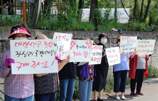 지난 3일 천안시 수신면 장산5리 주민들이 환경부 관계자들의 D공장 방문에 맞춰 손팻말을 들고 시위를 벌이고 있다. 사진=윤평호 기자
