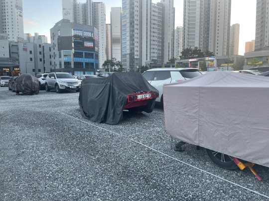 지난 24일 천안 불당동 임시공영주차장에 방수포로 덮힌 캠핑 트레일러들이 주차장 곳곳에 자리를 차지하고 있다. 사진=박하늘 기자
