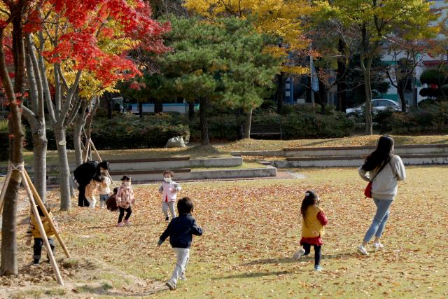 `위드 코로나` 시행 나흘째인 4일 대전시청 남문광장 놀이터를 찾은 유치원생들이 깊어가는 가을 단풍 아래서 야외학습을 하고 있다. 최은성 기자