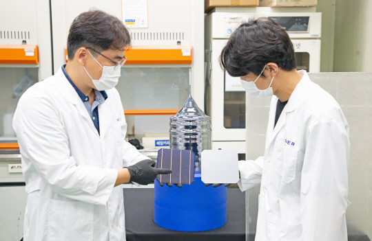 이진석 책임연구원(왼쪽)과 이준규 연구원이 태양광 폐패널로부터 회수한 실리콘을 재활용해 만든 웨이퍼와 태양전지를 들고 있다. 사진=한국에너지기술연구원 제공
