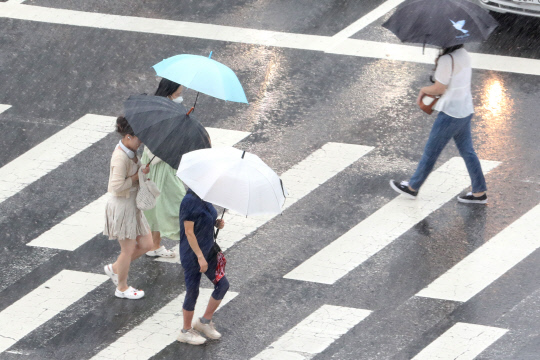 비가 내린 23일 대전 유성네거리 횡단보도에서 우산을 쓴 시민들이 발걸음을 재촉하고 있다.